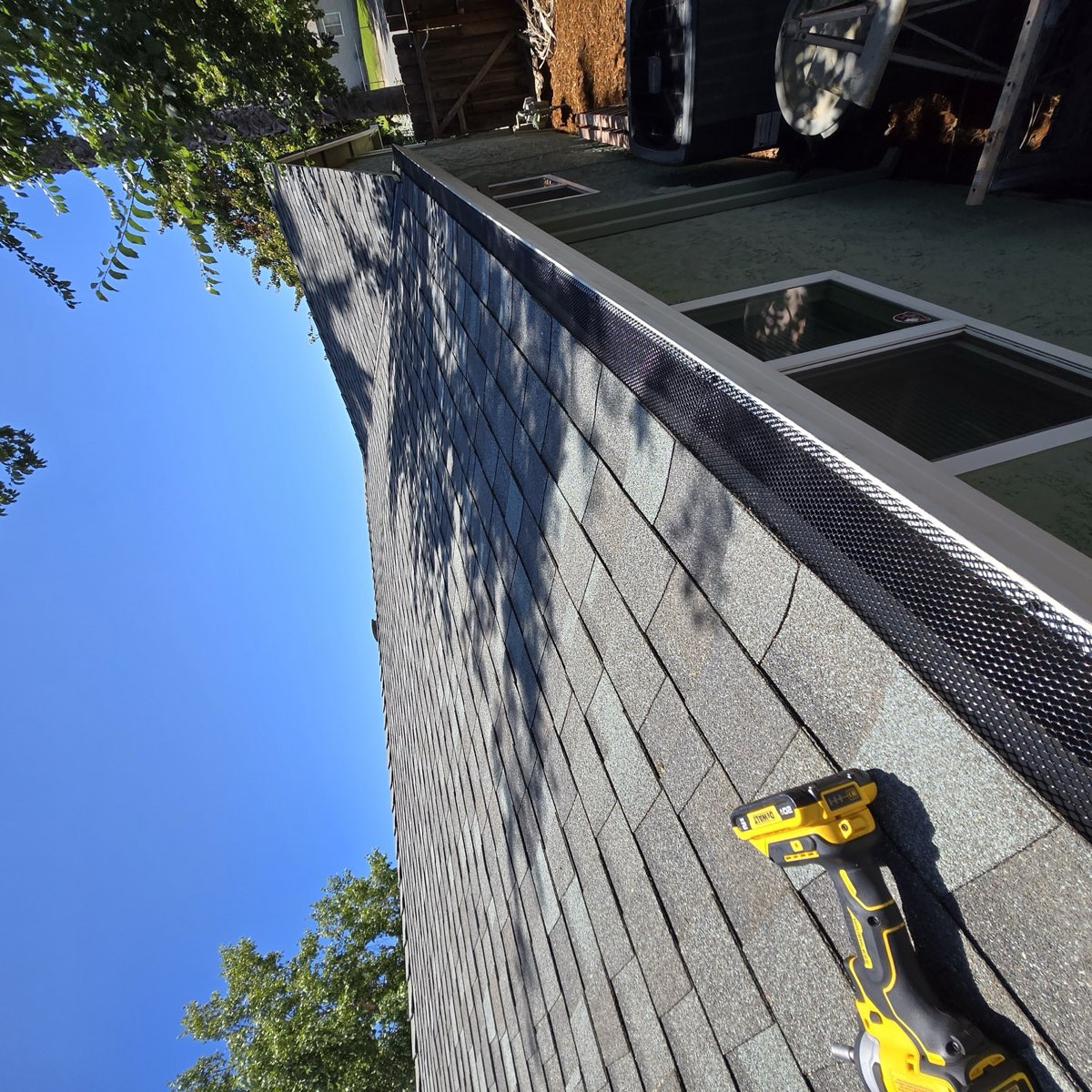 Gutter guard being installed with power drill on Sacramento rooftop