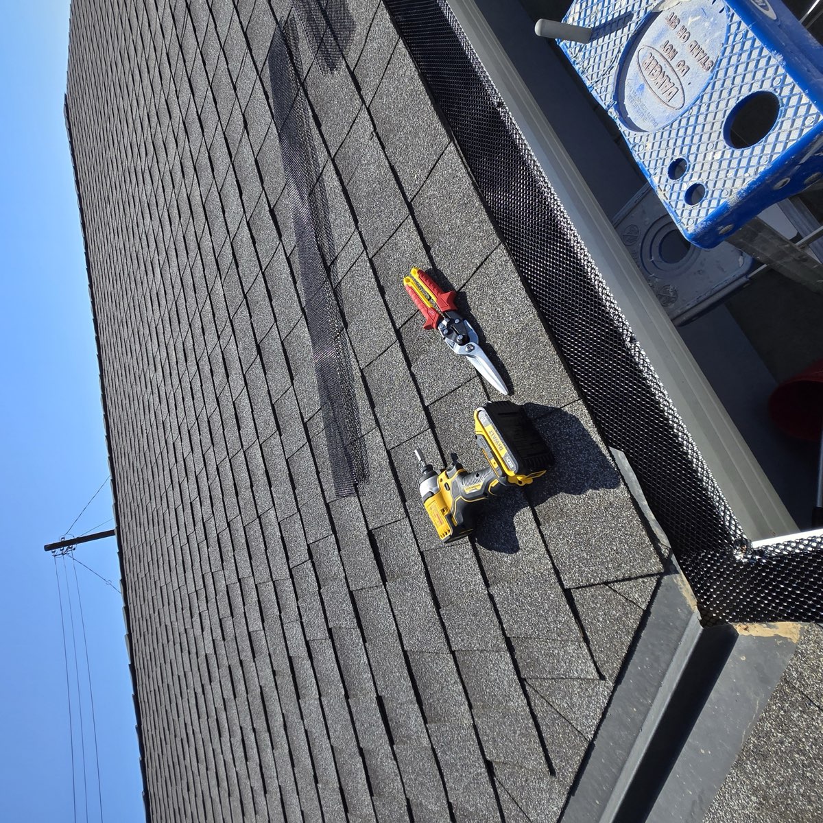 Gutter guard installation tools on shingle roof in Sacramento