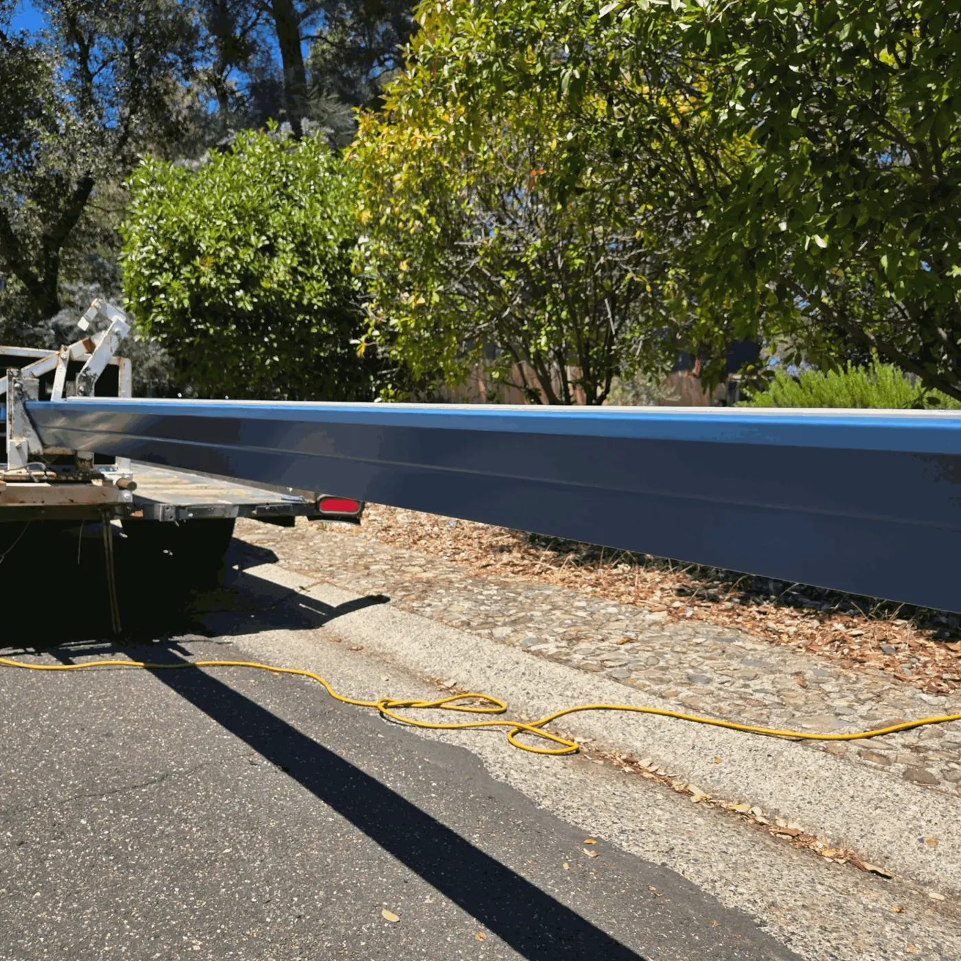 Seamless gutter run coming off the forming machine on the trailer at the curb
