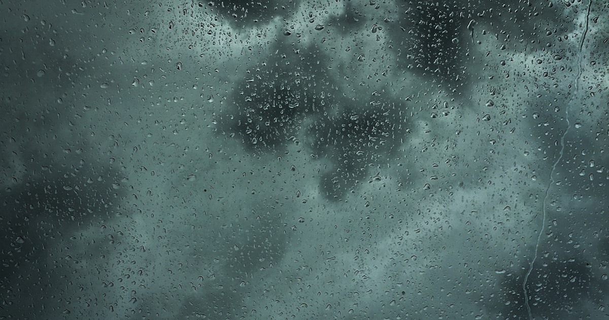 Heavy rain cascading off a Sacramento roof valley showing where water overshoots standard gutters during winter storms