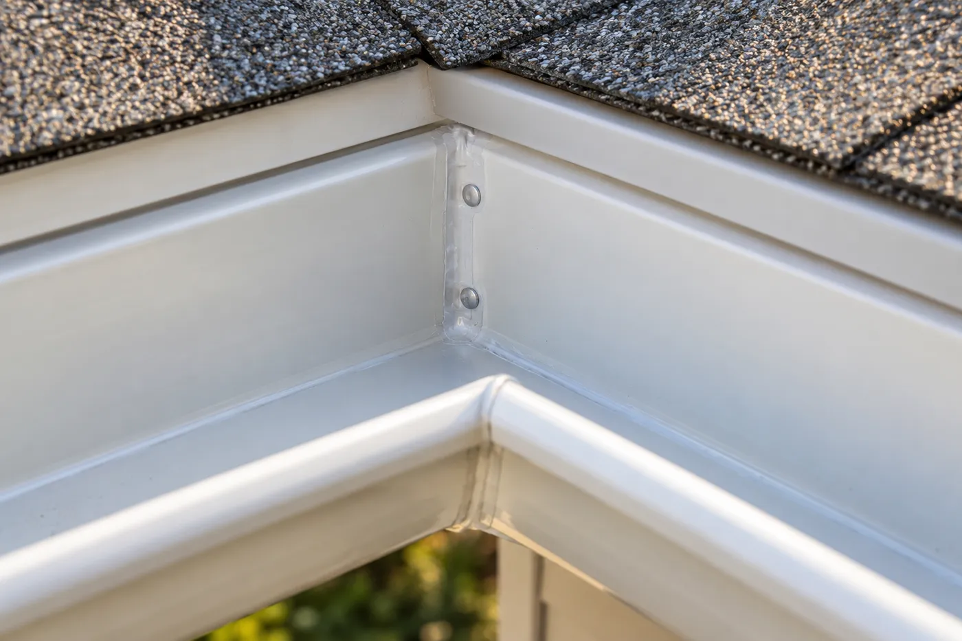 Fresh sealant along the mitered inside corner of a clean, empty seamless gutter