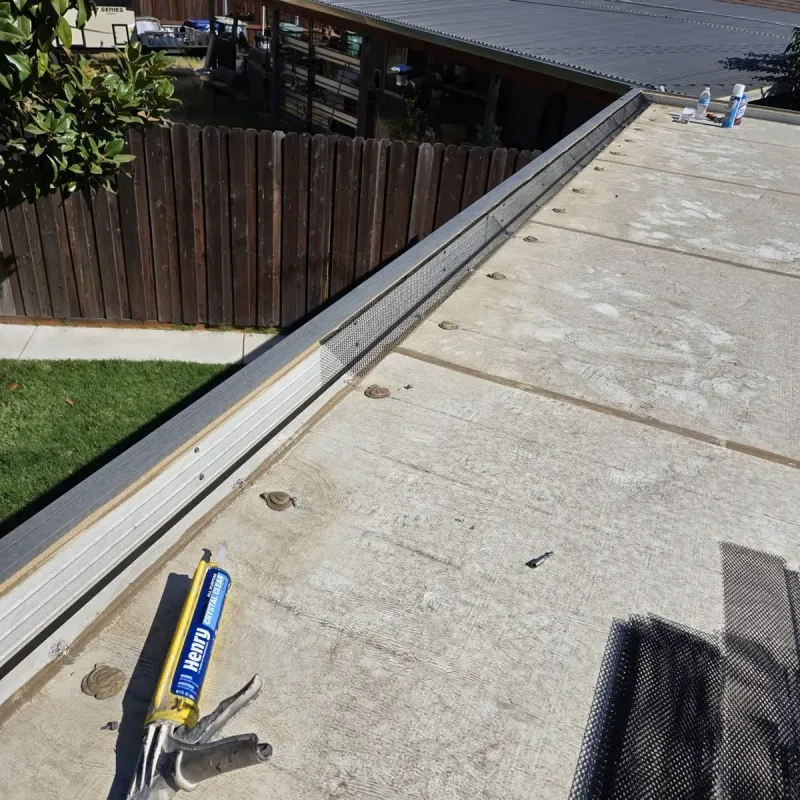 Gutter preparation with sealant and installation tools beside the roofline